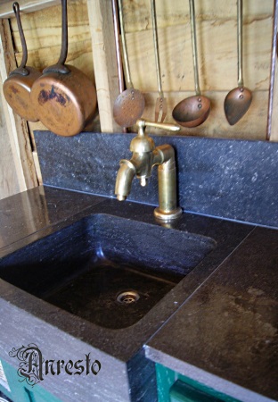 Opstaande hendel kraan gemonteerd op een blauwstenen keukenspoelbak